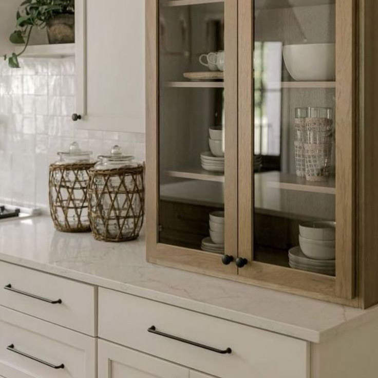 Timeless elegance meets warm, modern farmhouse charm, glass-front cabinets, natural textures, and soft neutrals create a beautifully inviting kitchen.