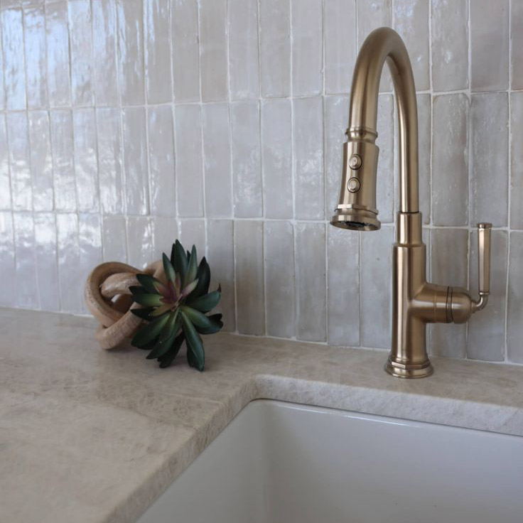 Classic textures and warm metallics, this brass faucet and zellige tile backsplash add an elegant touch to a classic kitchen space.